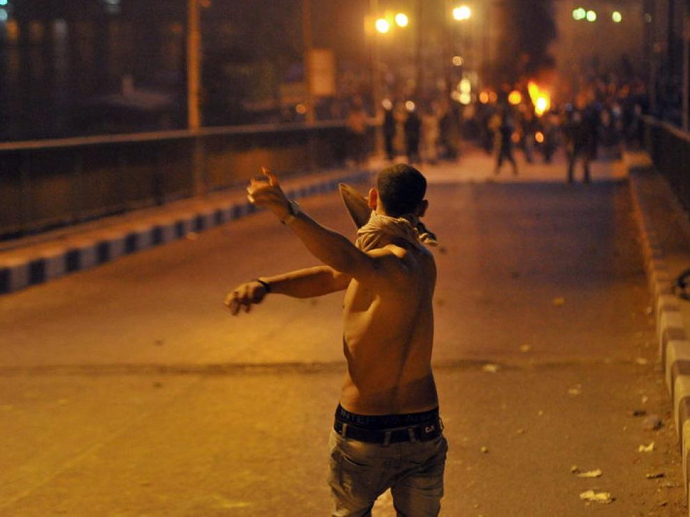 .- Un joven egipcio enfrenta a fuerzas de seguridad egipcias durante una protesta llevada a cabo frente al edificio de la radiotelevisión en El Cairo