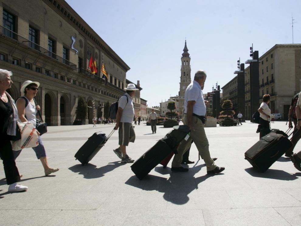 Un grupo de turistas camina por la plaza del Pilar de Zaragoza
