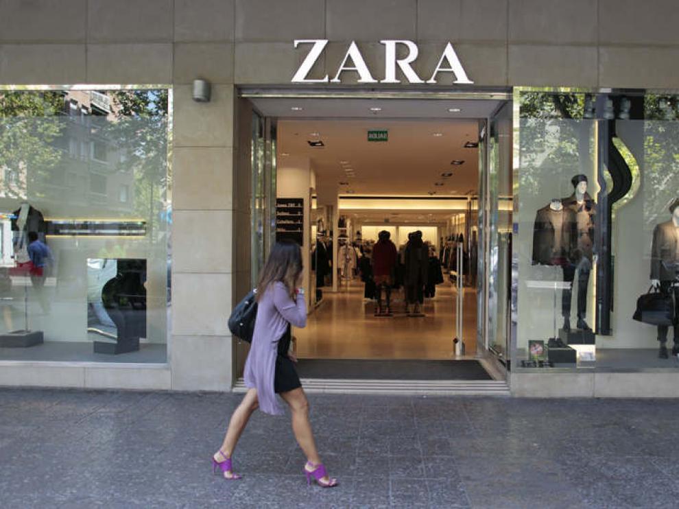 Una joven pasea frente a un escaparate.