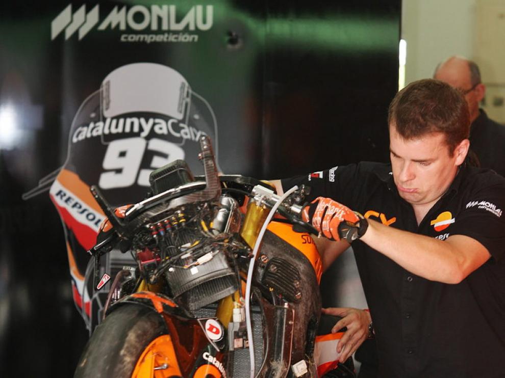 Un mecánico mueve la moto accidentada del piloto español Marc Marquez