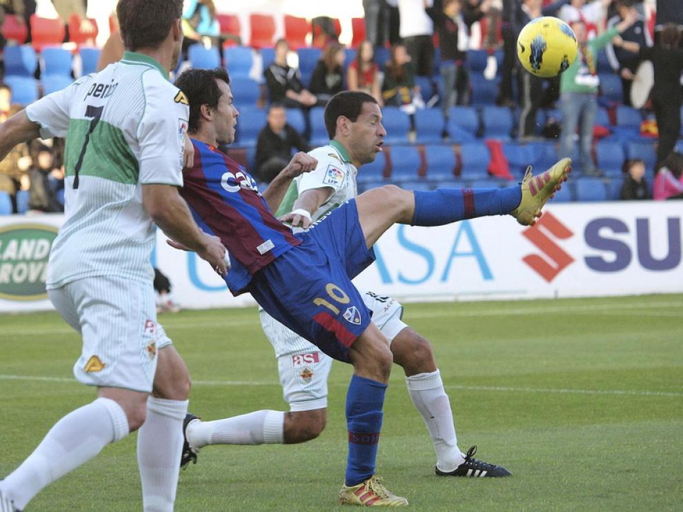 Camacho trata de controlar el balón ante dos defensores del Elche