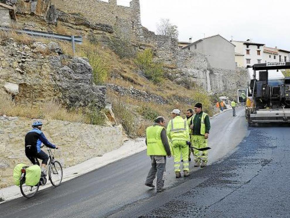 Los operarios extienden una nueva capa de asfalto en la carretera a la entrada de Cantavieja.