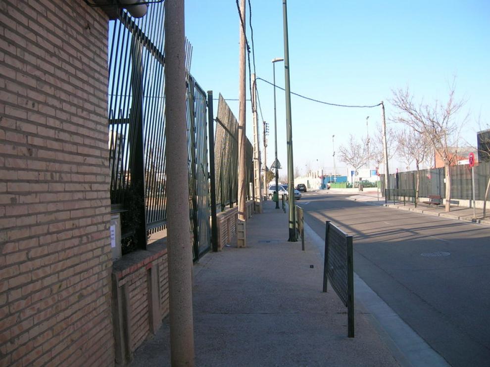 Los postes de tendido eléctrico flanquean la entrada del Colegio Público Guillermo Fatás