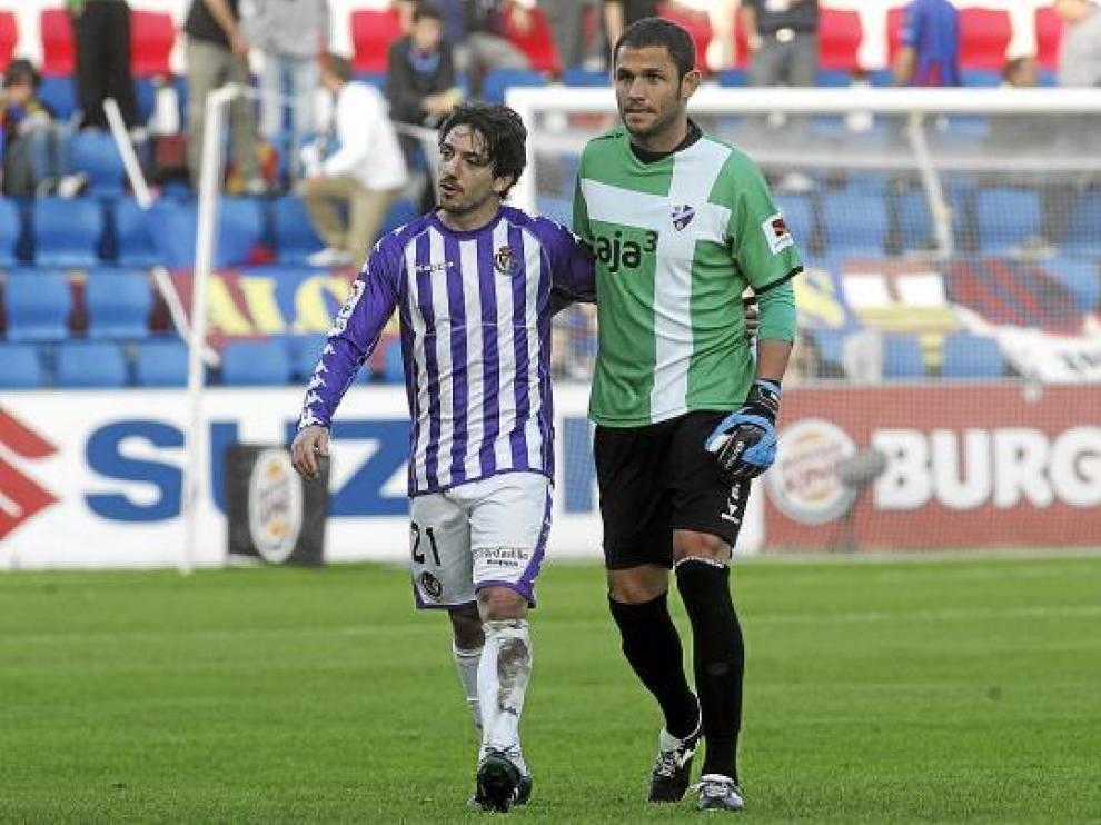 Luis García, abrazado con el pucelano Sisi. Encajó dos goles en su estreno con el Huesca.