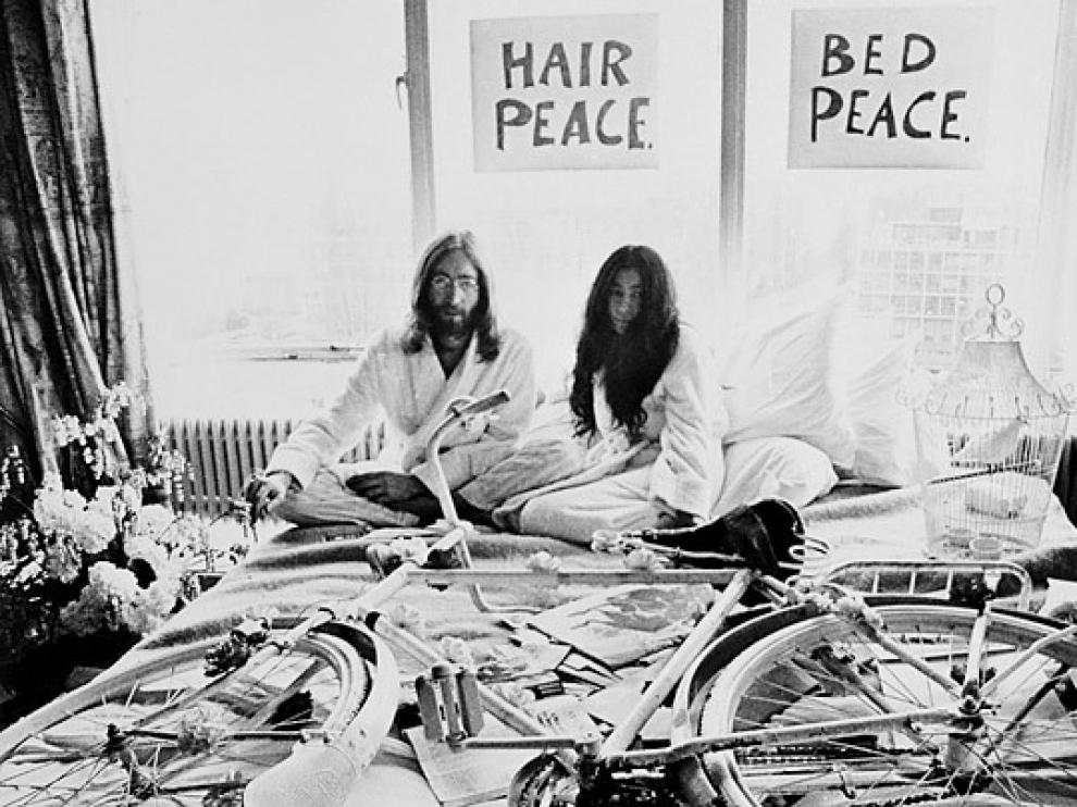 Yoko Ono y John Lennon en la cama con el cartel colgado