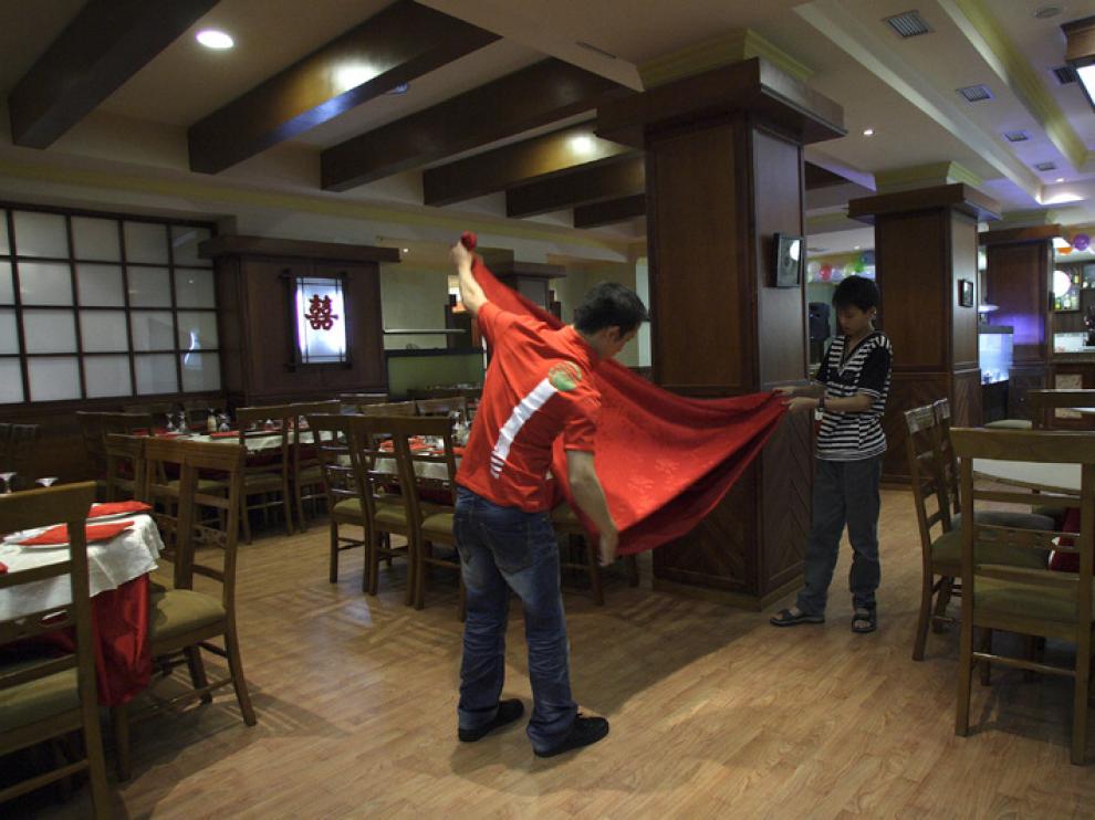 Unos empresarios de nacionalidad china trabajan en su local hostelero