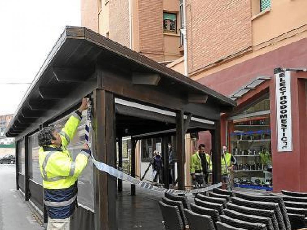 Operarios municipales desmantelan la terraza.