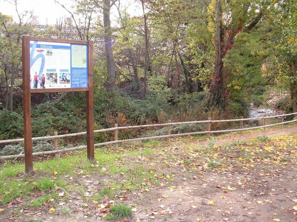 Comienzo del sendero en dirección al humedal de Cortés y la fuente de Marcelo, con su panel explicativo.