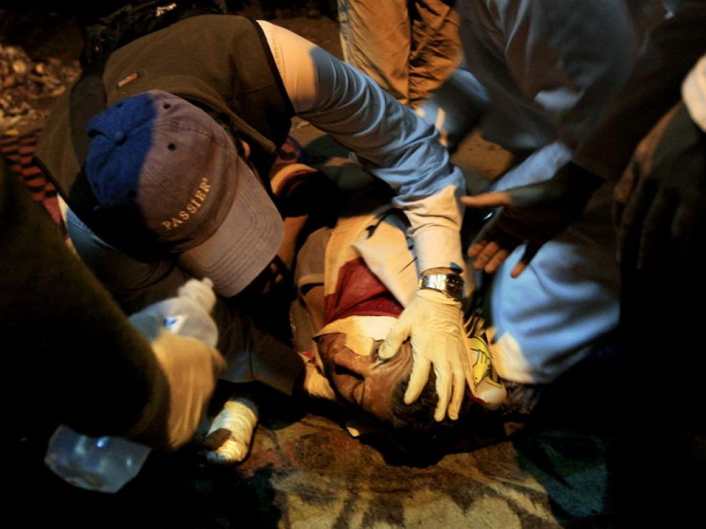 Los médicos atienden a un herido durante los enfrentamientos acontecidos en la plaza de Tahrir.