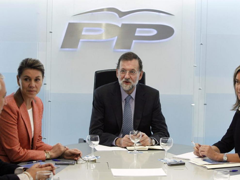 El líder del PP, Mariano Rajoy, acompañado de la secretaria general, María Dolores de Cospedal (i) y la vicesecretaria de Organización del PP, Ana Mato, durante la reunión que mantuvo hoy en Génova con los miembros del Comité de Dirección de su partido