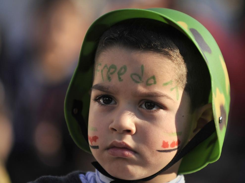 Un niño sirio con la palabra libertad pintada en la cara