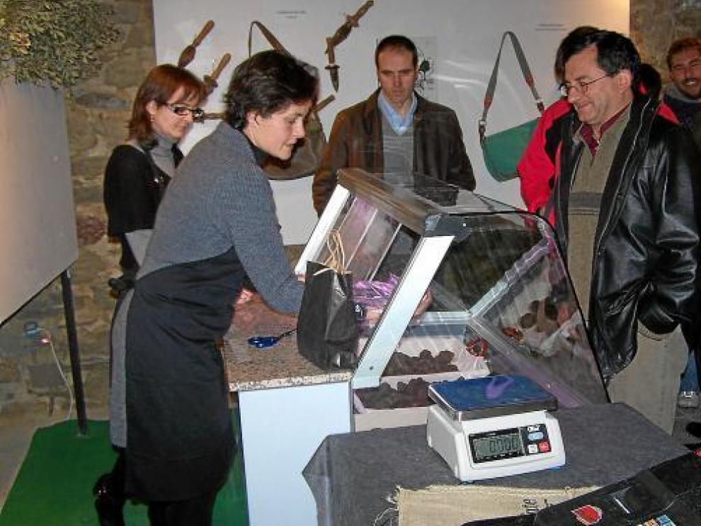 Varios turistas (el pasado invierno) se interesan por la trufa que oferta el mercado de Graus.