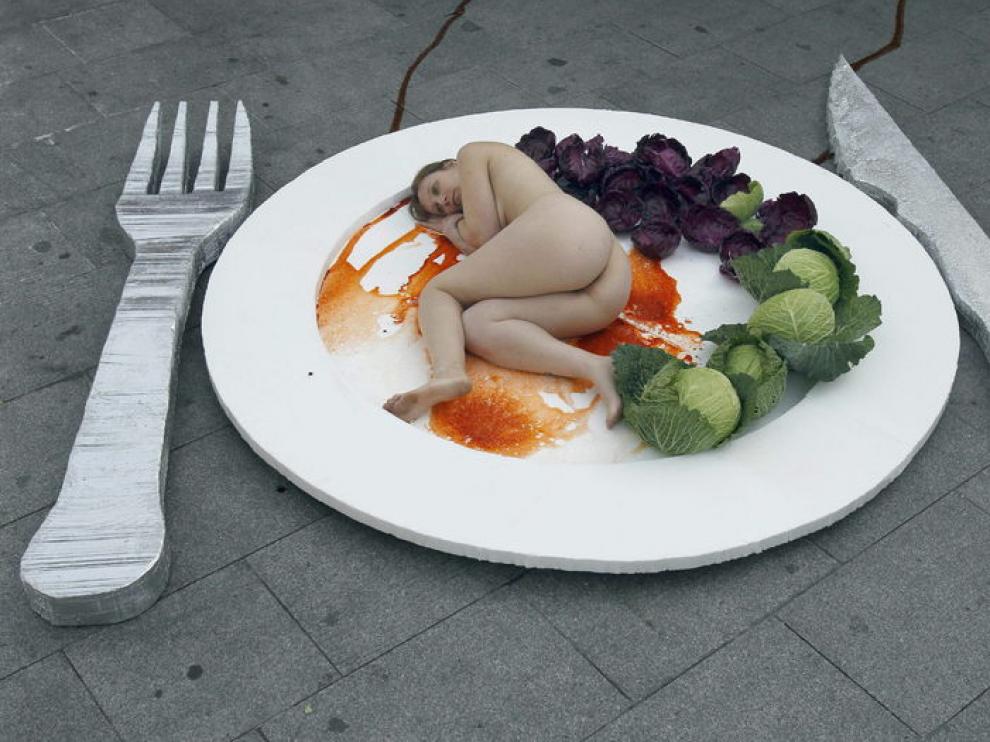La organización AnimaNaturalis ha realizado hoy en Barcelona una performance con un plato gigante que simula ser carne humana