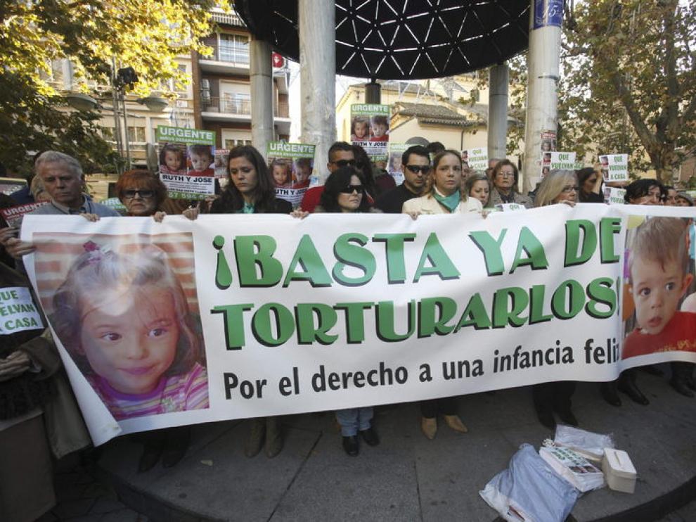 La madre de los niños, en el centro de la pancarta, con gafas de sol