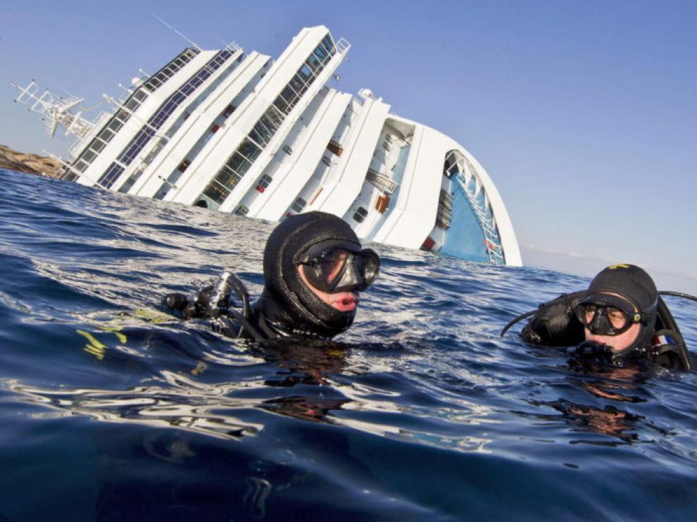 Buceadores de los Carabiniari italianos en el agua cerca del crucero Costa Concordia