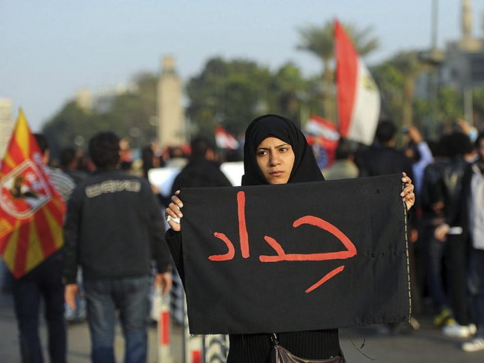 Una mujer porta un cartel que muestra la palabra "luto" por los disturbios ocurridos en Port Said.