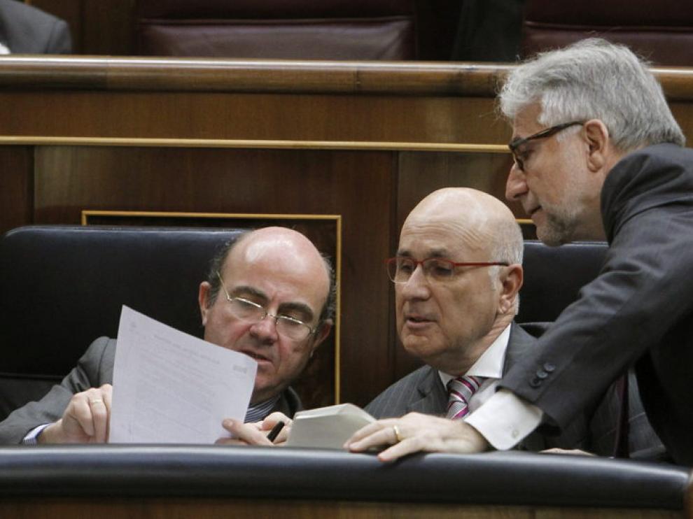 De Guindos (i), conversa con el portavoz de CiU Josep Antoni Duran y LLeida (c) y con el diputado de CiU Josep Sánche Llibre (d)