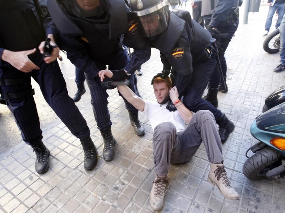 La policía custodia a un manifestante durante las protestas de Valencia.
