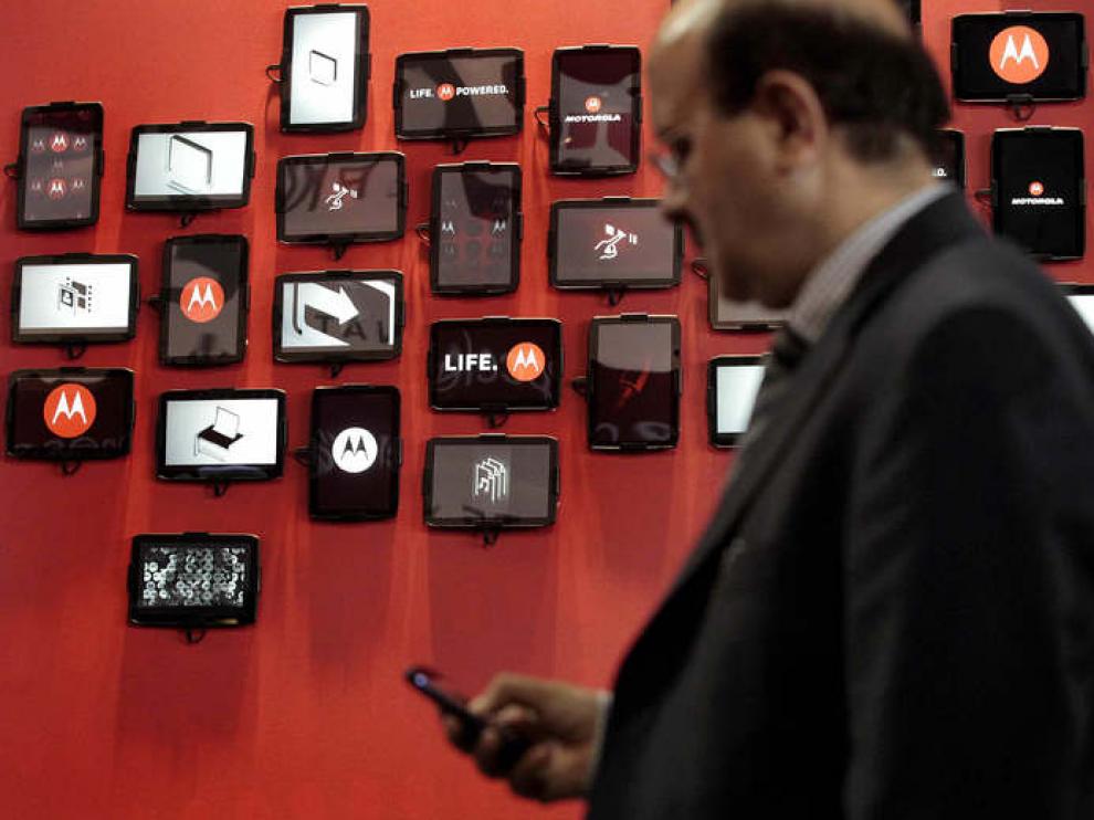 Un hombre consulta su móvil frente al stand de Motorola en el Mobile World Congress.