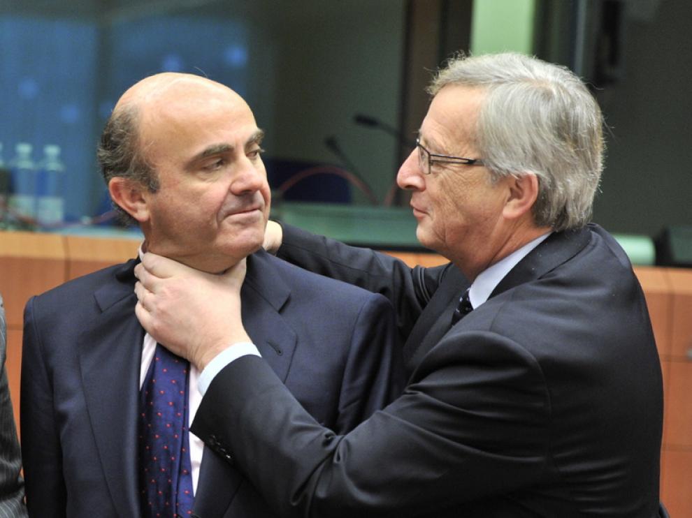 Jean-Claude Juncker y De Guindos bromean durante la reunión