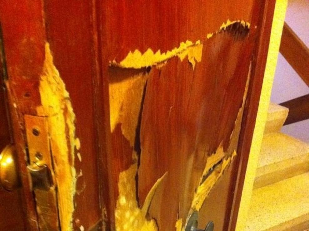 Aspecto de la puerta de una vivienda zaragozana tras ser reventada