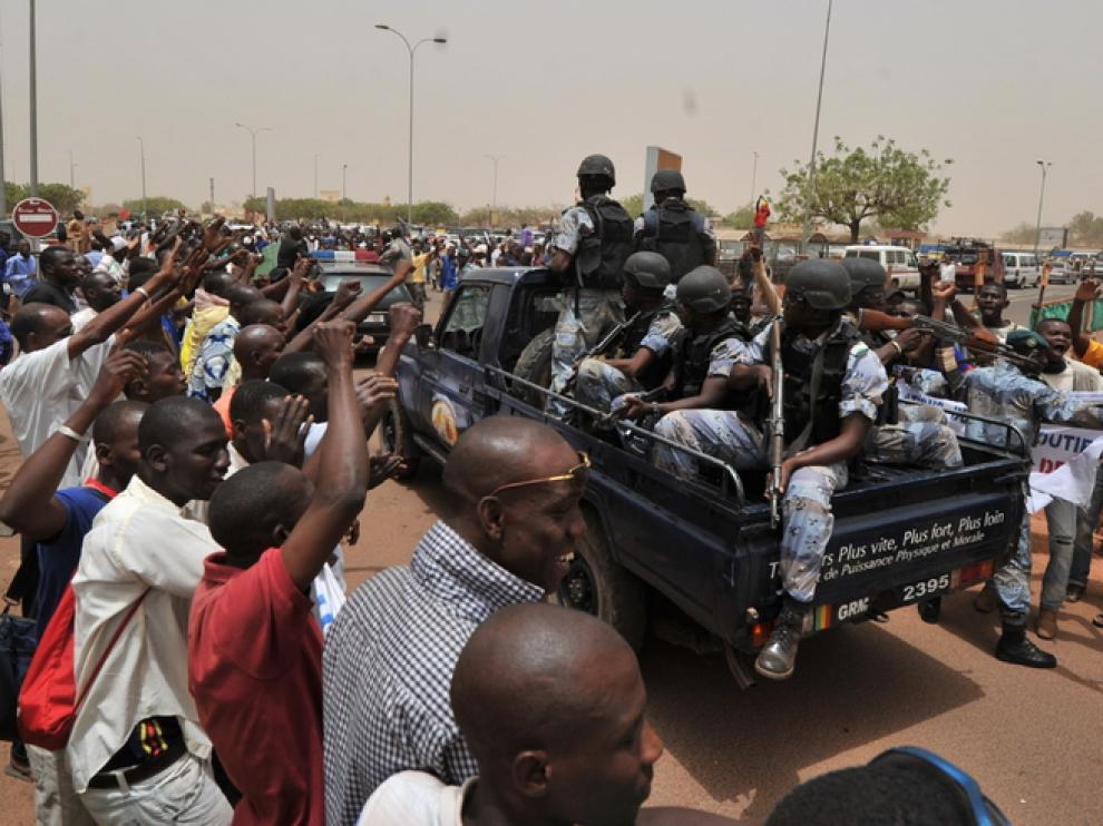 Partidarios de la Junta militar de Mali se concentran alrededor de un camión cargado con soldados.
