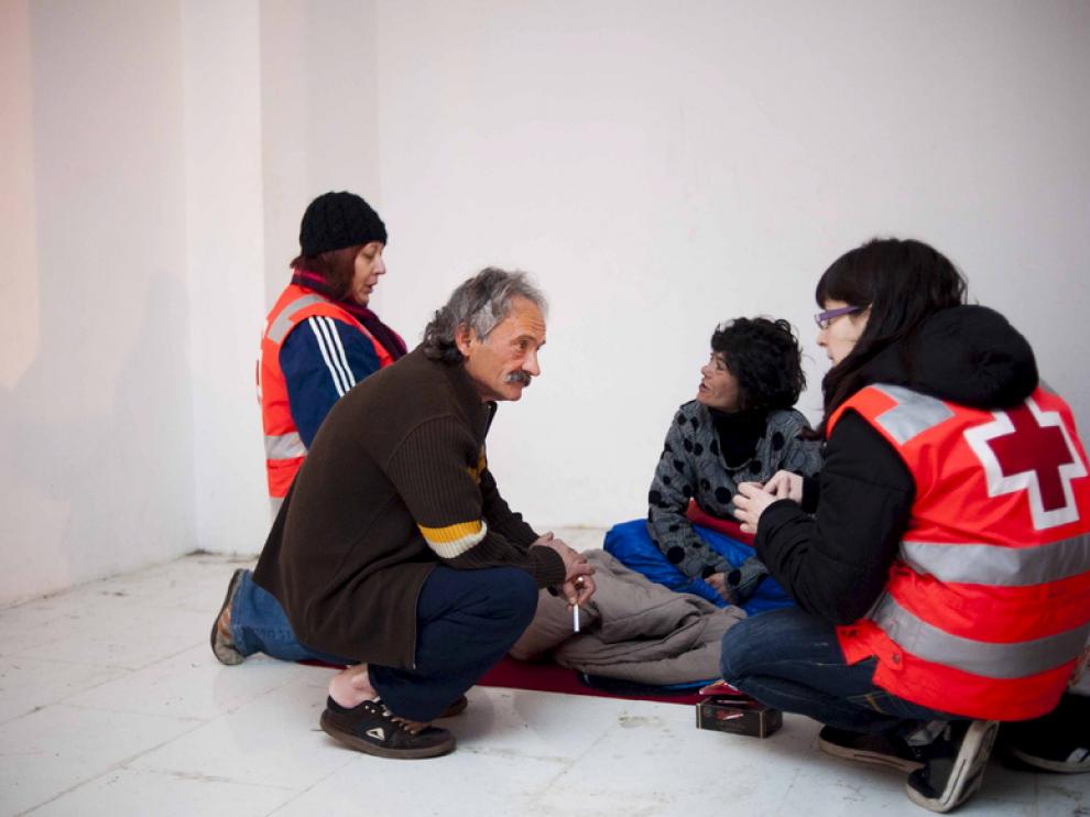 Voluntarios de la Cruz Roja ayudan a un sintecho