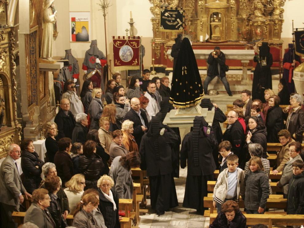 La virgen es llevada a hombros en el interior de la iglesia de Alcalá de Gurrea para protegerla de la lluvia.