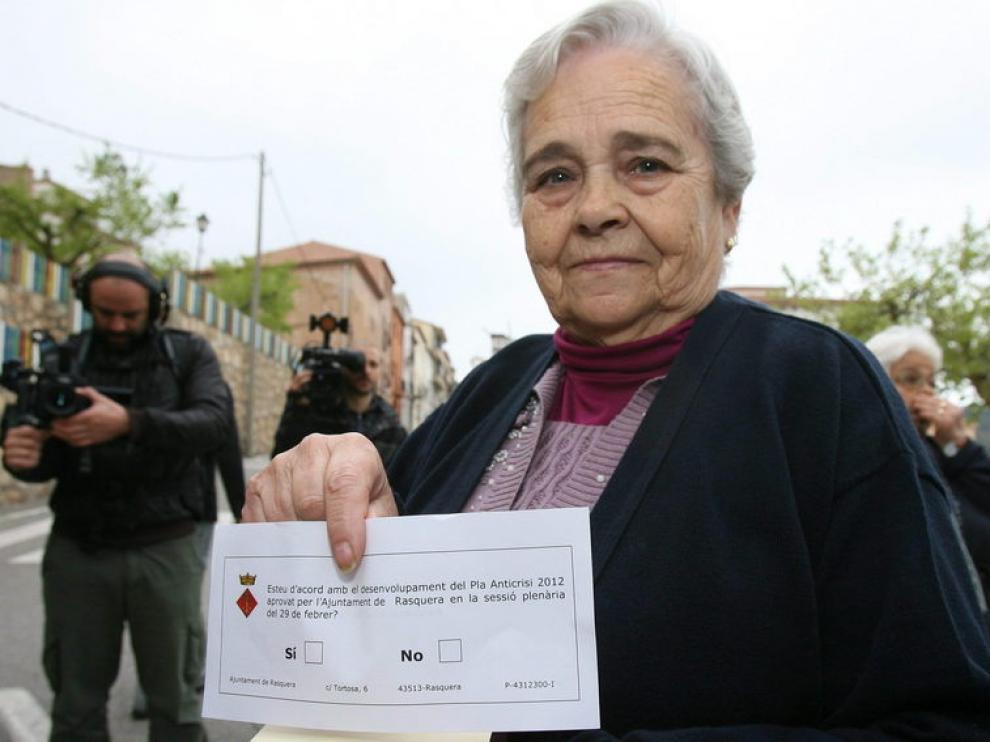 Una vecina muestra la papeleta para participar en el referendo.