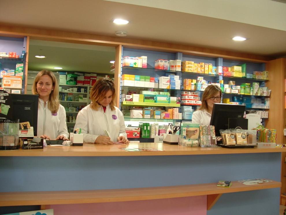 Raquel Ciriza, a la derecha de la imagen, tras el mostrador de su farmacia junto a dos empleadas