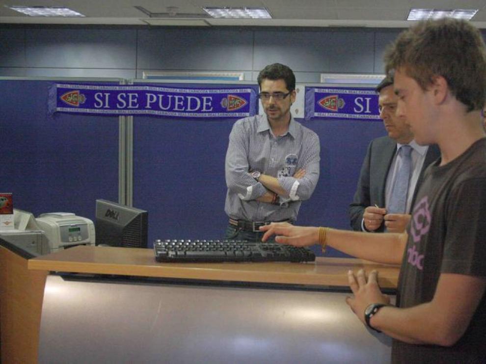 El voluntario, Julián Borque, pulsa el botón de inicio del sorteo.