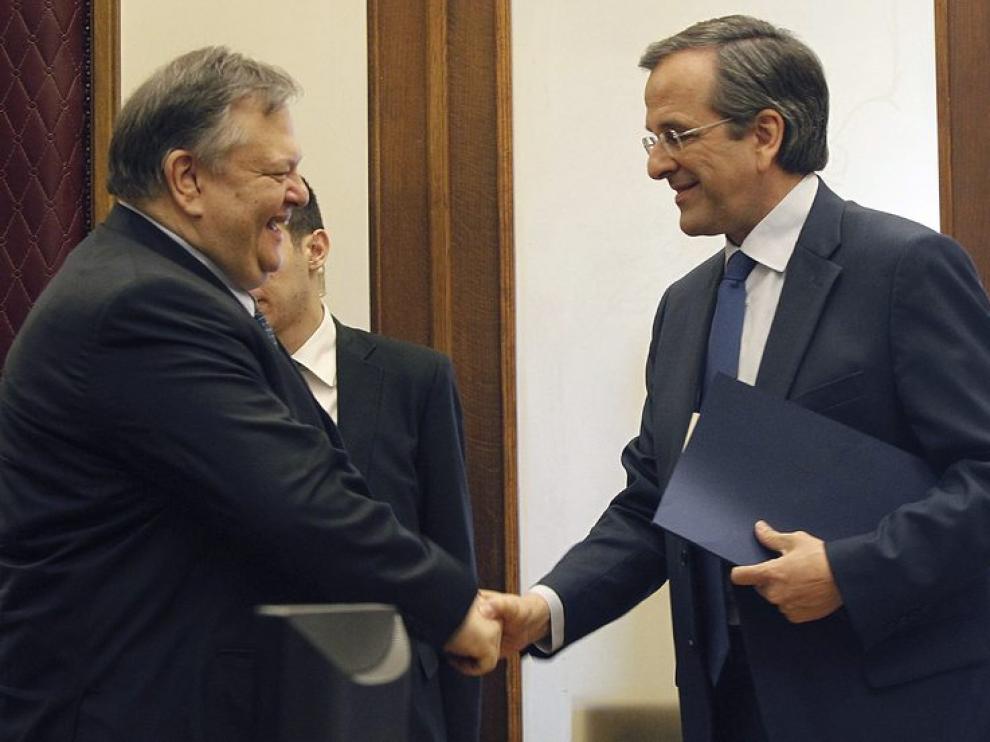 Evangelos Venizelos (izda) estrecha la mano de Antonis Samaras (dcha)