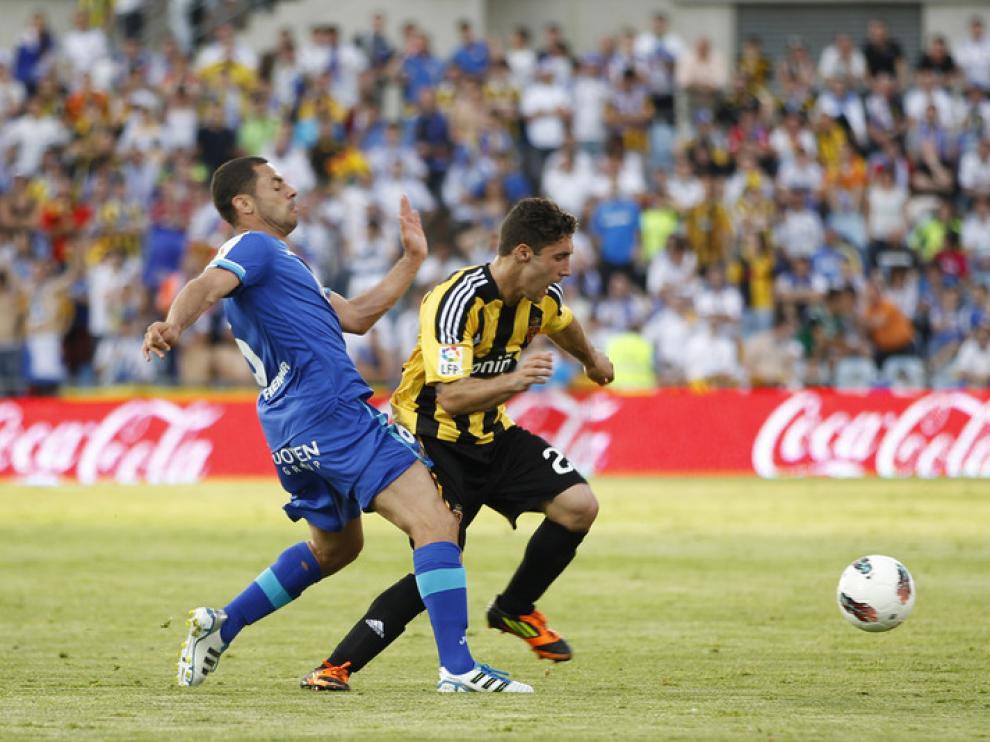 El defensa del Getafe CF Rafa López (d) pugna por el balón con el argentino Franco Zuculini