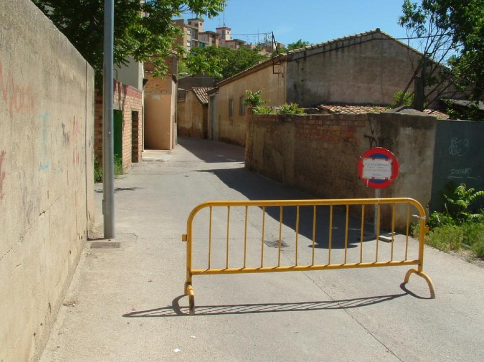 La entrada a la calle desde Ronda del Isuela presenta una valla de obra y una señal que informa del cierre al tráfico