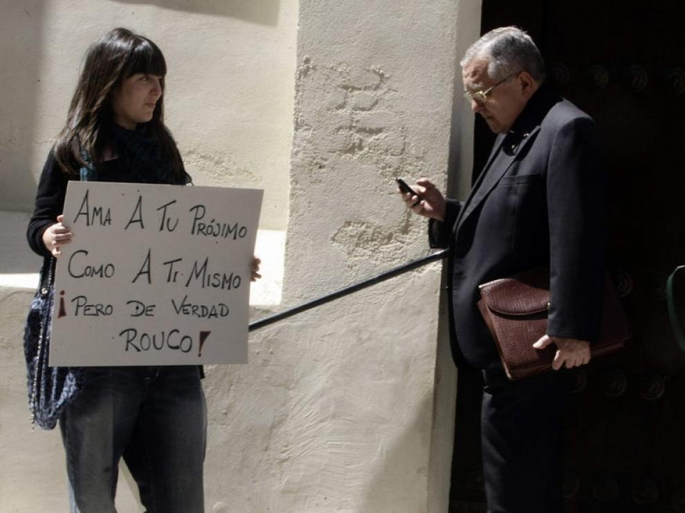 Una indignada del 15M espera a la salida de la conferencia del cardenal Rouco Varela.