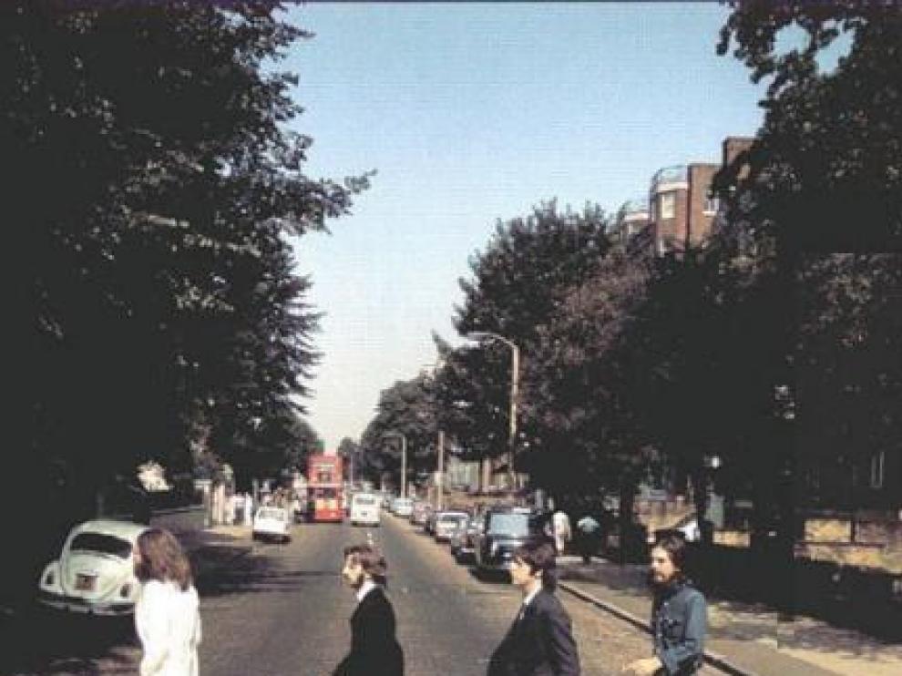 Los Beatles cruzando Abbey Road en sentido contrario a la portada del disco