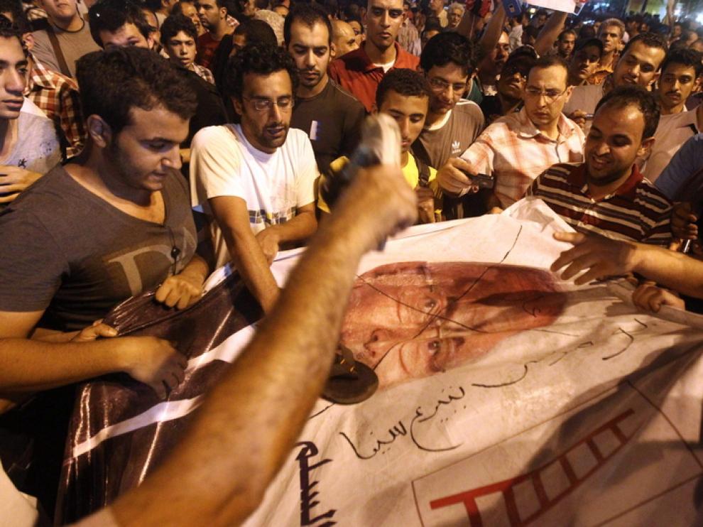 Los manifestantes pintan un cartel del candidato presidencial