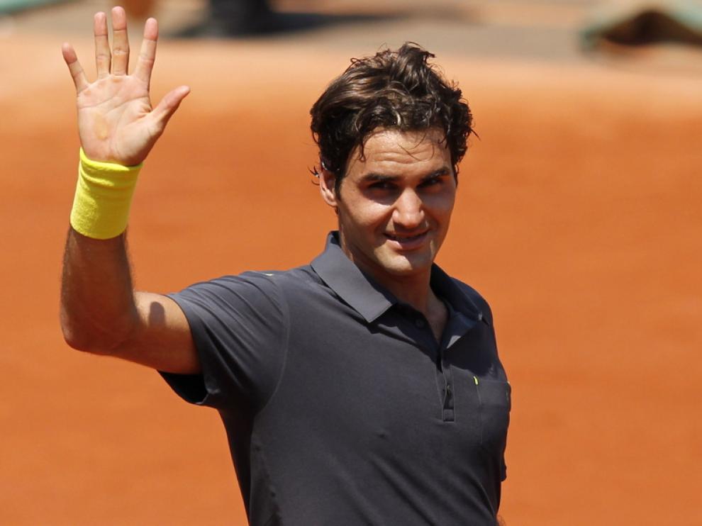 Roger Federer saluda al público tras conseguir su victoria 233 en Gran Slam