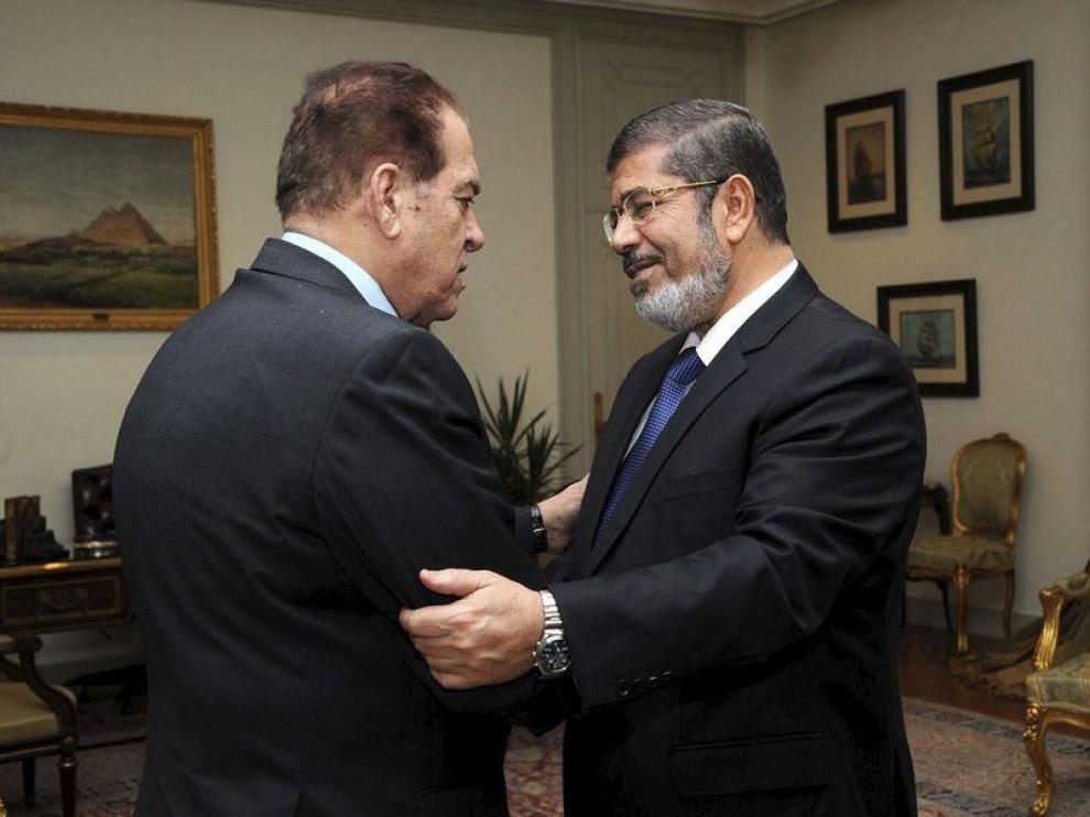 Mohamed Mursi (dcha), saludando al primer ministro saliente, Kamal Ganzouri