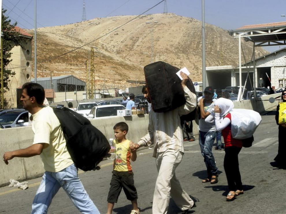 Familias sirias curzan la frontera libanesa con Siria.
