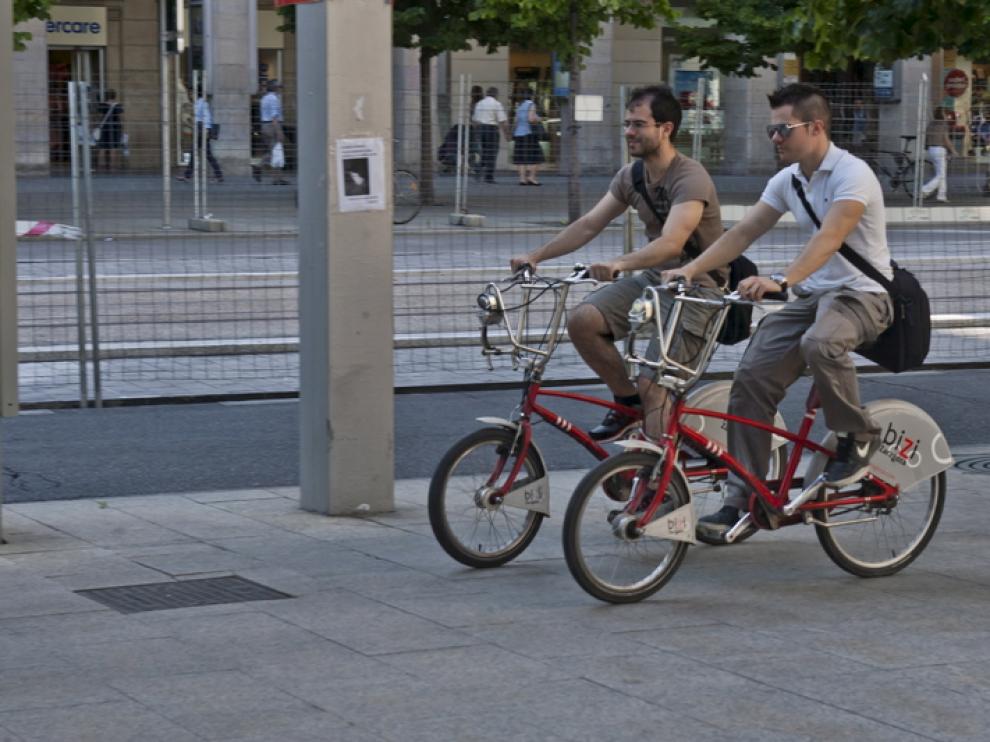 Dos ciclistas circulan por la acera del paseo de la Independencia