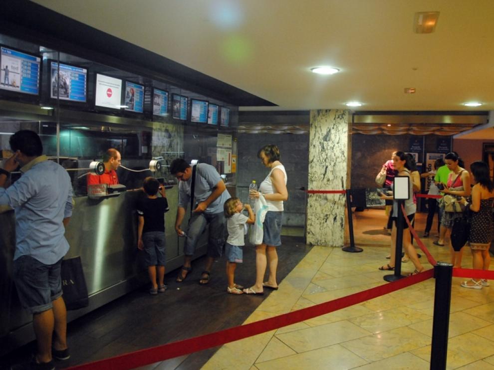 Varias personas hacen fila en la taquilla de un cine zaragozano