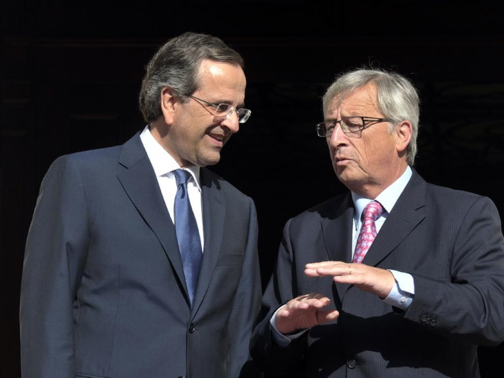 El primer ministro griego, Antonis Samaras, habla con Juncker, director del Eurogrupo