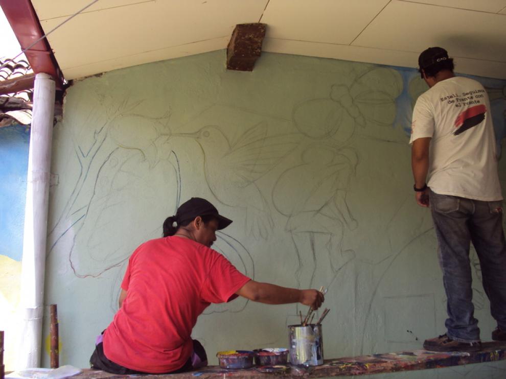 Unos jóvenes pintan un mural en León