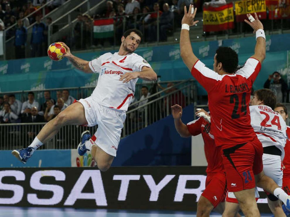 El español Alberto Entrerríos lanza ante el pivote de Egipto, Elmasry
