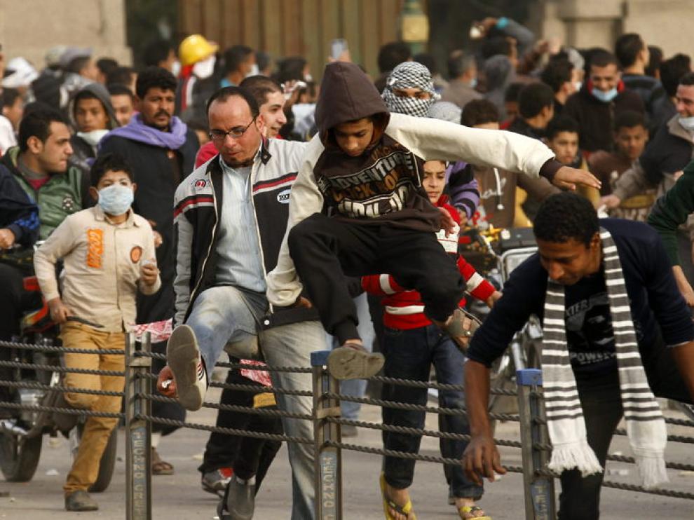 Protestantes egipcios huyendo de los gases lacrimógenos