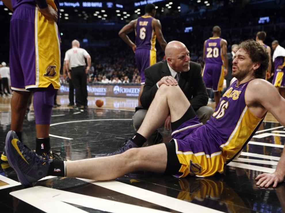 Un miembro del equipo médico asiste a Gasol en el partido ante los Nets