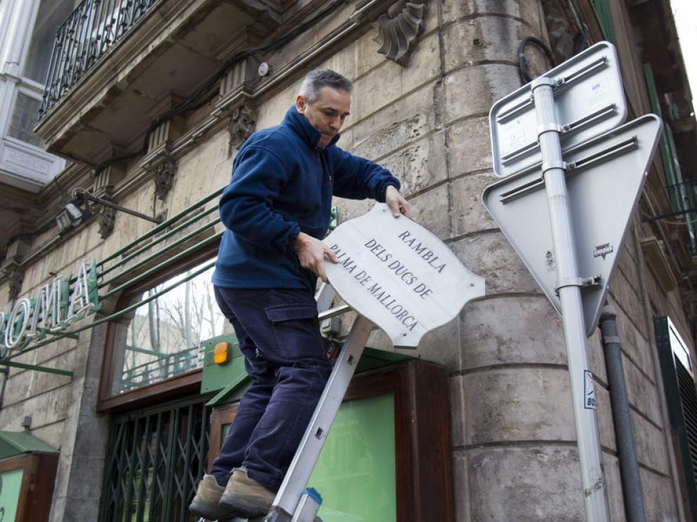 Un operario del Ayuntamiento retira la placa con el nombre antiguo de La Rambla