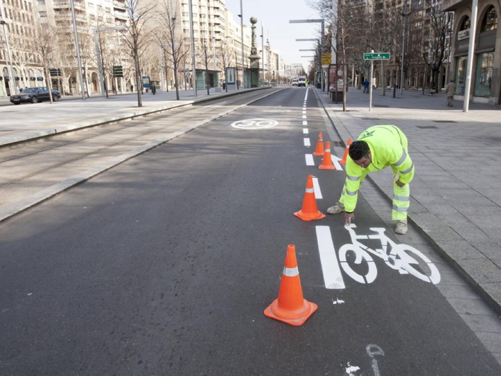Un empleado pinta el carril bici en Independencia