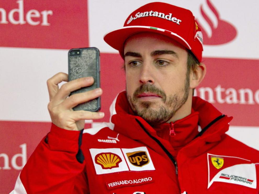 Alonso tomando fotos con su móvil en Montmeló